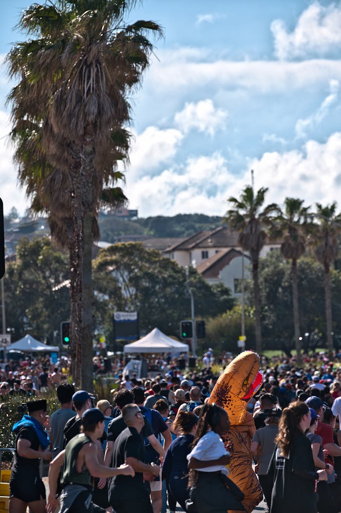 A lively charity run event at Bondi Beach with participants dressed in costumes under a bright sky.